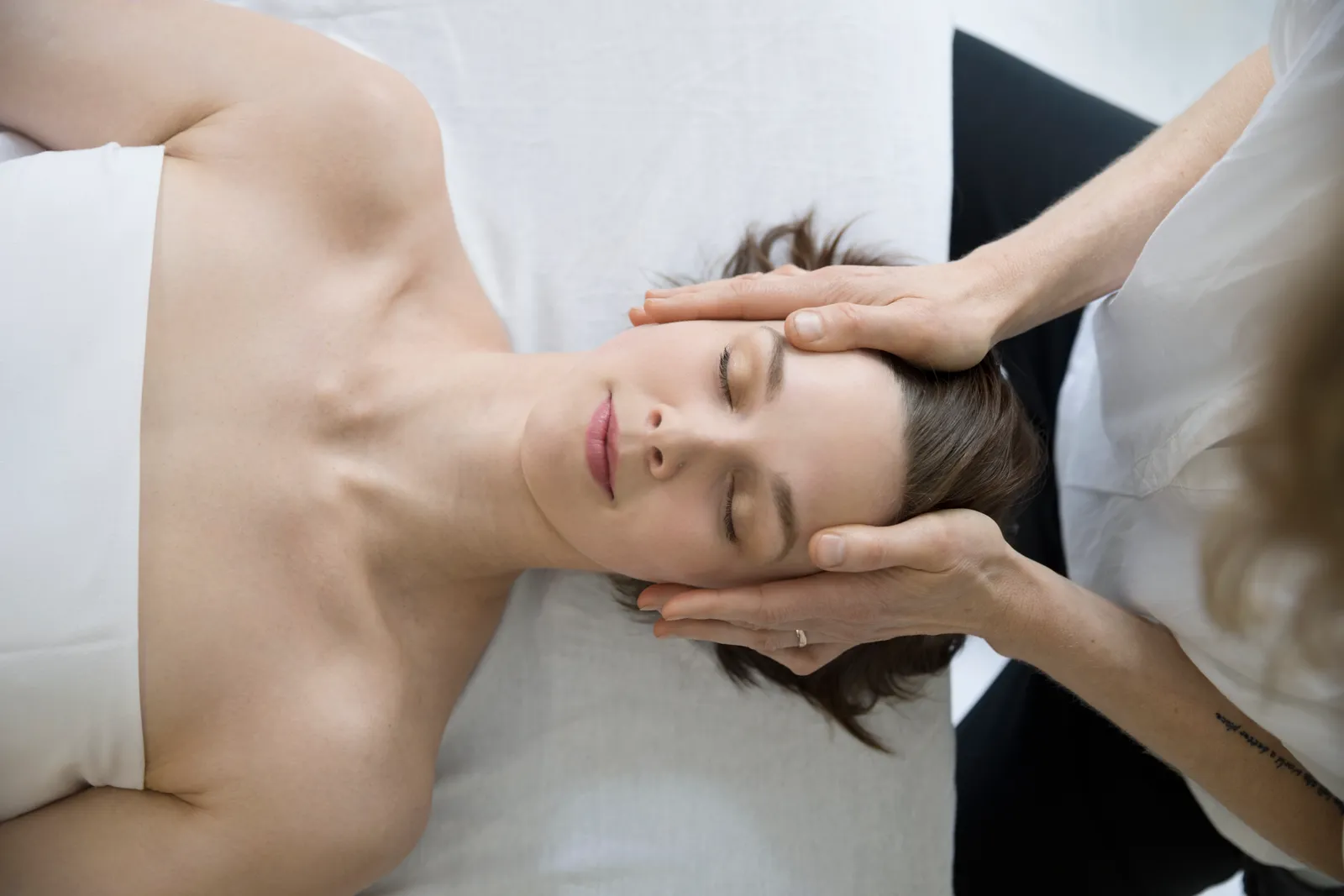 Woman lying down enjoying a Sculpting facial lift massage technique